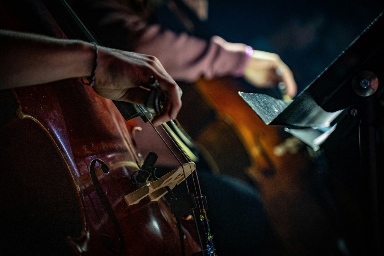 A close-up of people playing string instruments